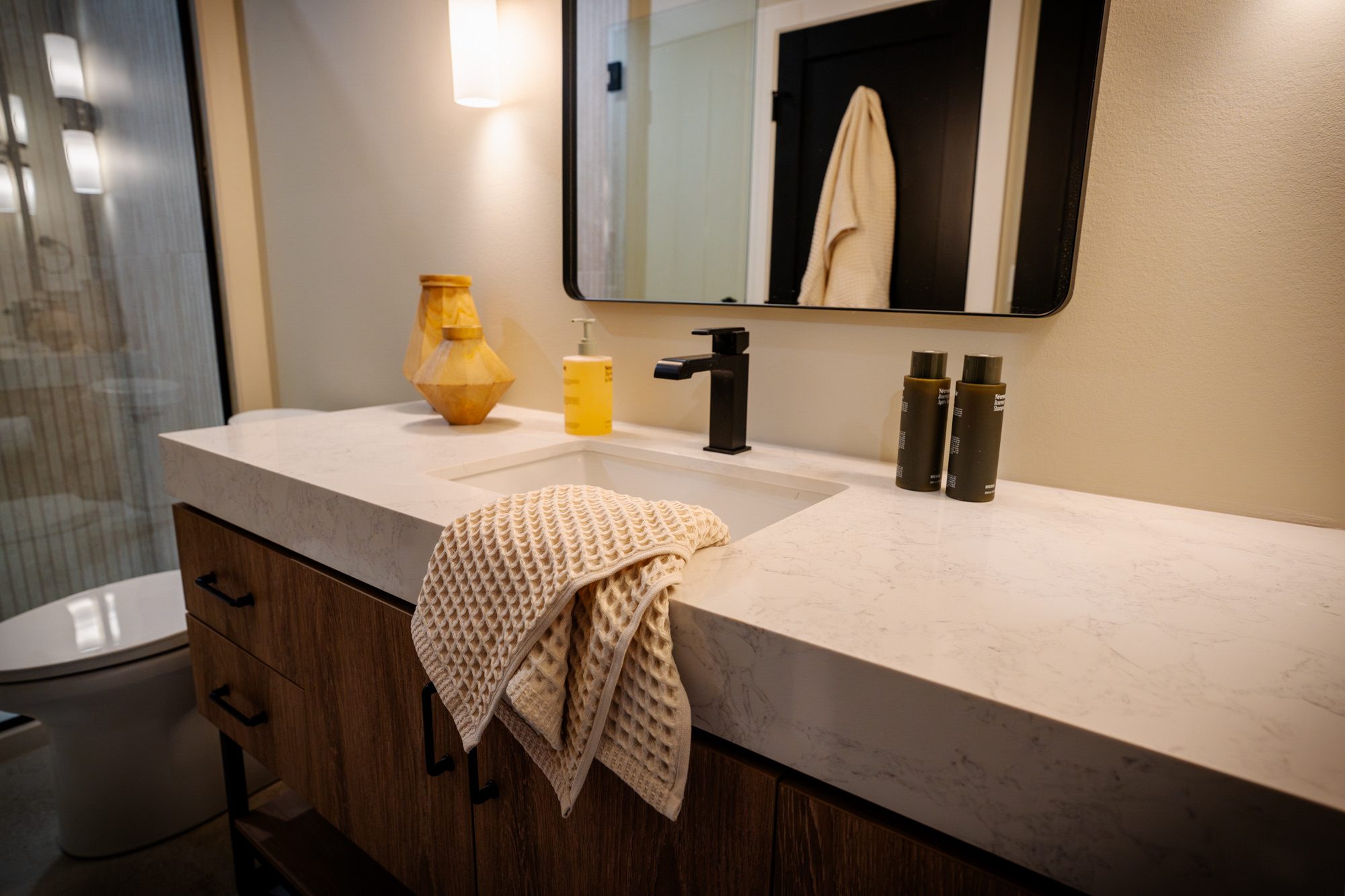 Bathroom vanity with a thick quartz top and a black faucet