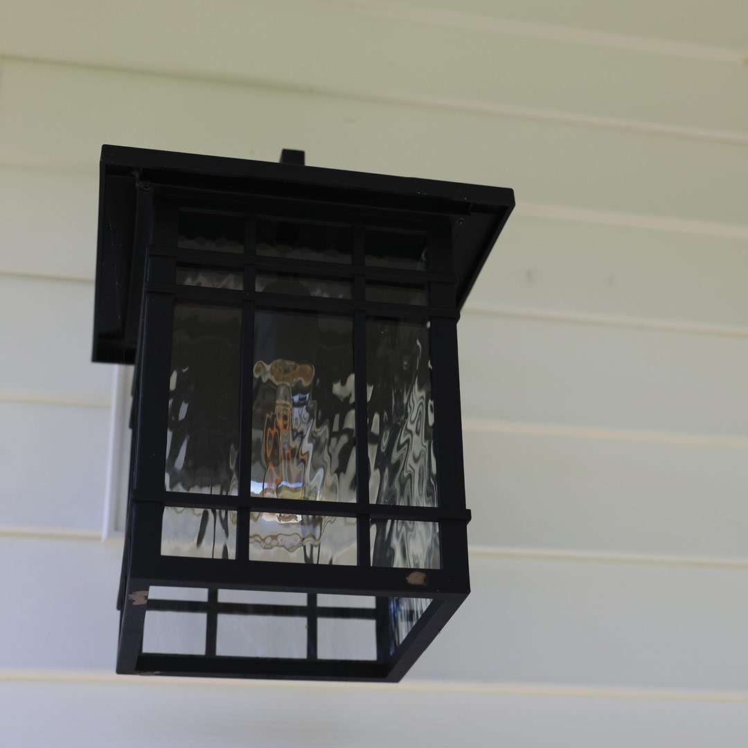 Siding_019 Black outdoor lantern fixture with glass panels, enhancing home exterior aesthetics and lighting.
