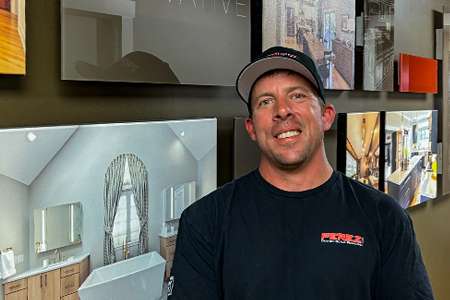 2024_employee_photo_Jason_Bello Jason Bello, head of Landscape Division at Perez Design Build Remodel, smiling in front of design displays, showcasing expertise in landscape design and construction.