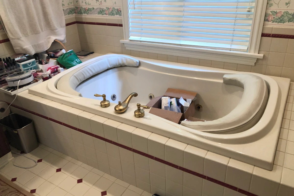 Dated bathroom with platform tub before remodel in Dallas, PA